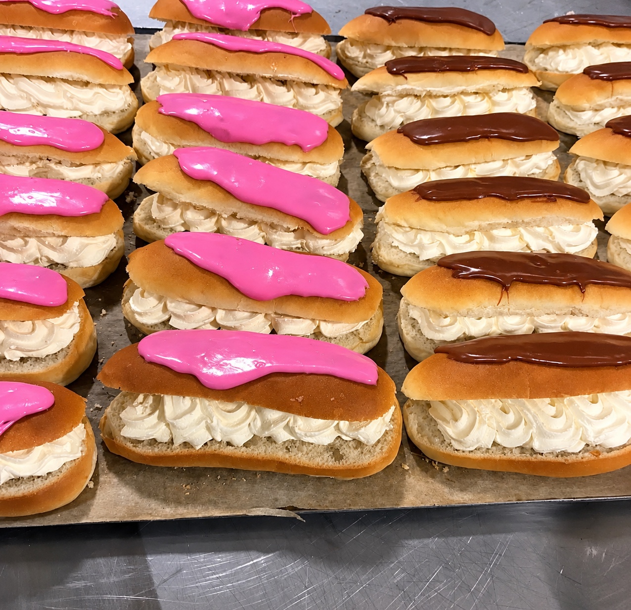 Cream-filled buns with pink and chocolate icing